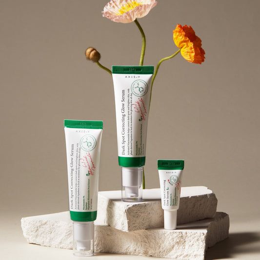 Axis-Y Dark Spot Correcting Glow Serum tube with green cap and white body.