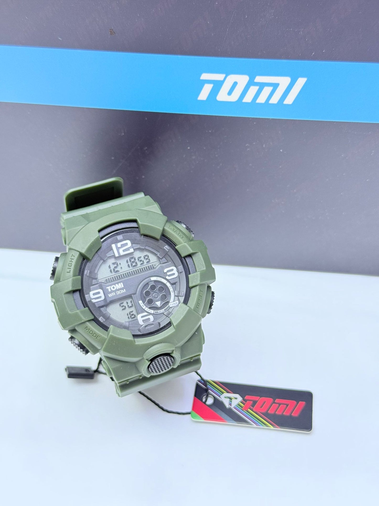 Army green Tomi sports digital analog wristwatch with rugged military design.